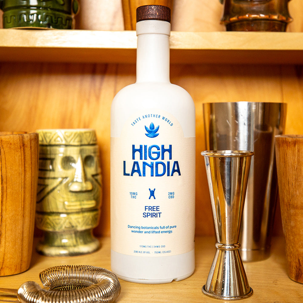 Highlandia Free Spirit 10mg THC drink mixer bottle in a tiki bar next to a jigger and hawthorn strainer